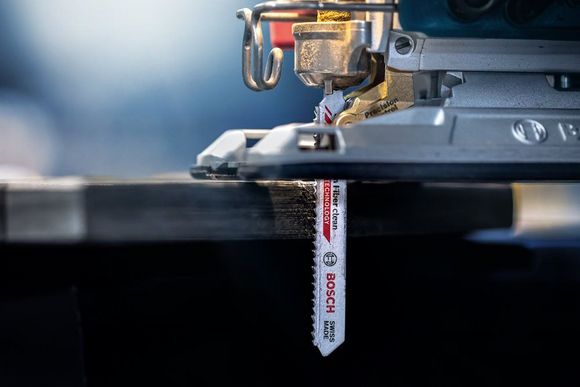 Stichsäge sägt in dunkles Holz